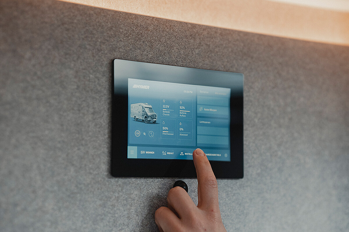Smarte Technologien einfach nachrüsten mit unseren Kleinkrediten. Ein Finger tippt auf ein Touchdisplay zur Steuerung der Wohnmobilheizung.