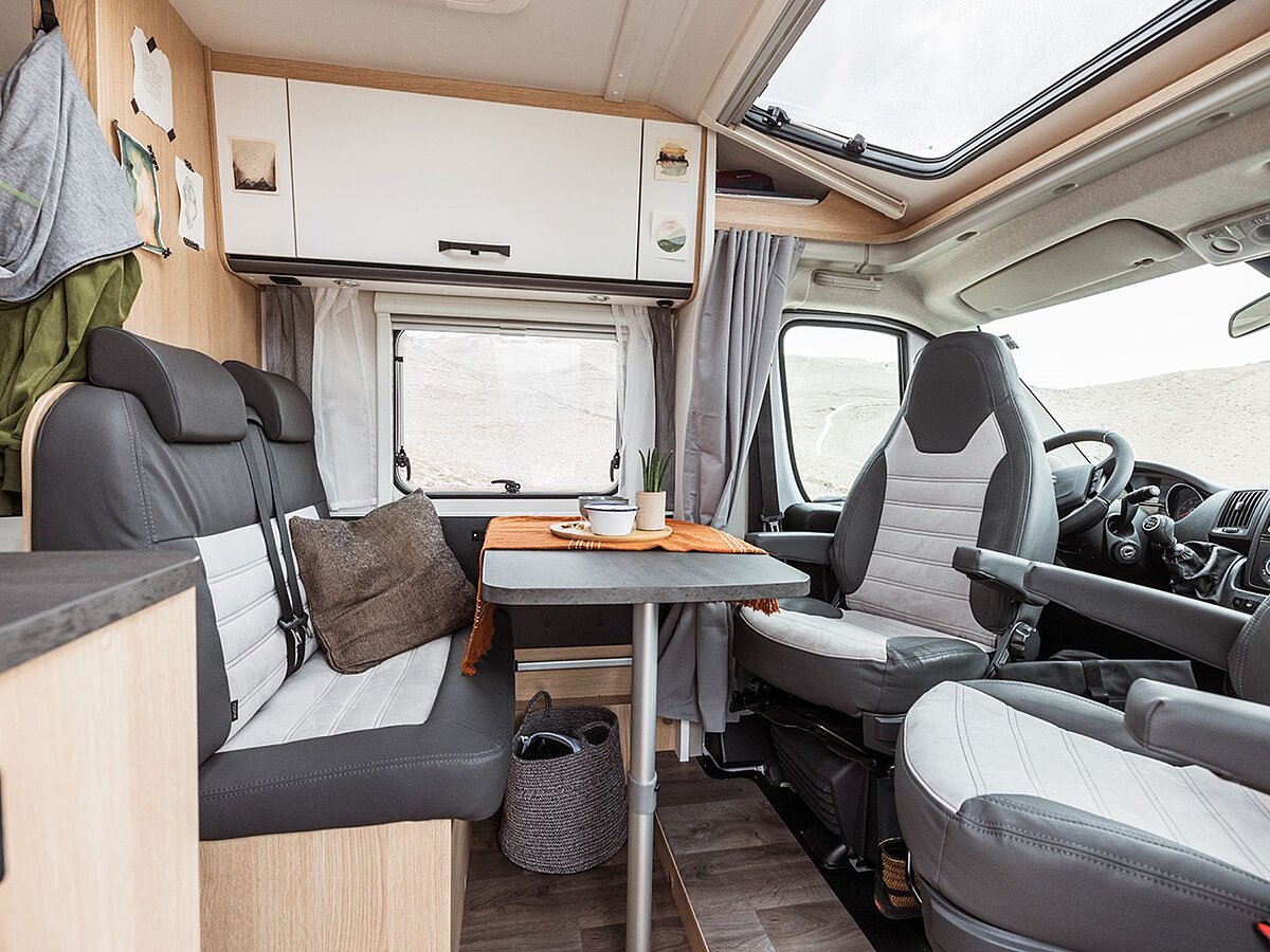 Die Sitzgruppe und das Fahrerhaus mit umgedrehten Sitzen eines Wohnmobils